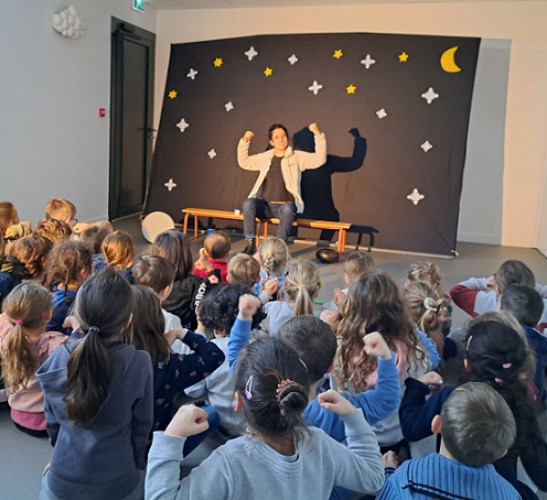 Photo d'un spectacle en école maternelle de la conteuse, Lucie Chaudy et de son public reprenant un refrain